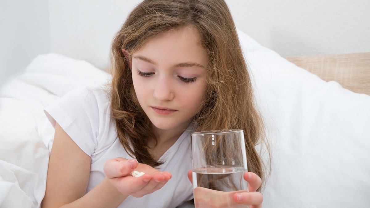 Chica joven tomando medicación