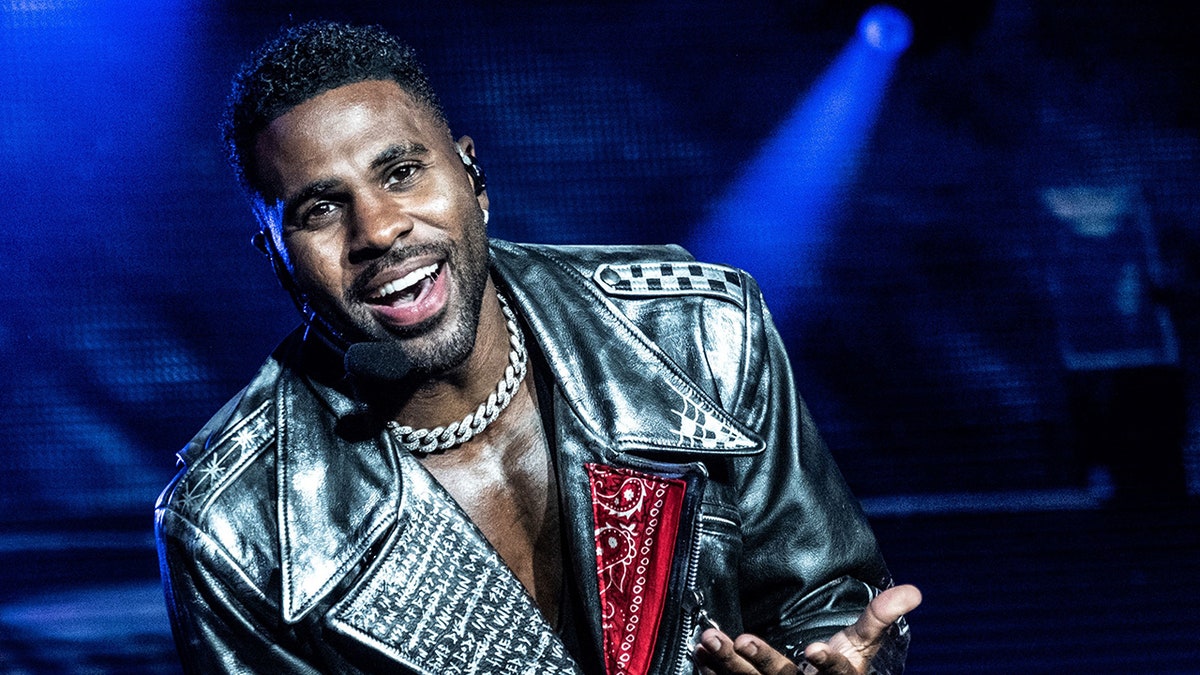 Jason DeRulo sings on stage in Denmark with a silver chain necklace and a black leather jacket
