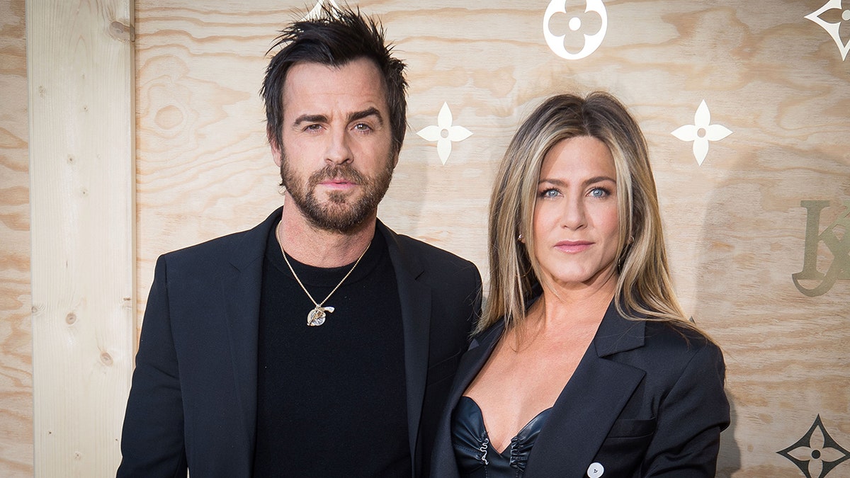 Justin Theroux and Jennifer Aniston both in navy ensembles at the Louis Vuitton Dinner in Paris