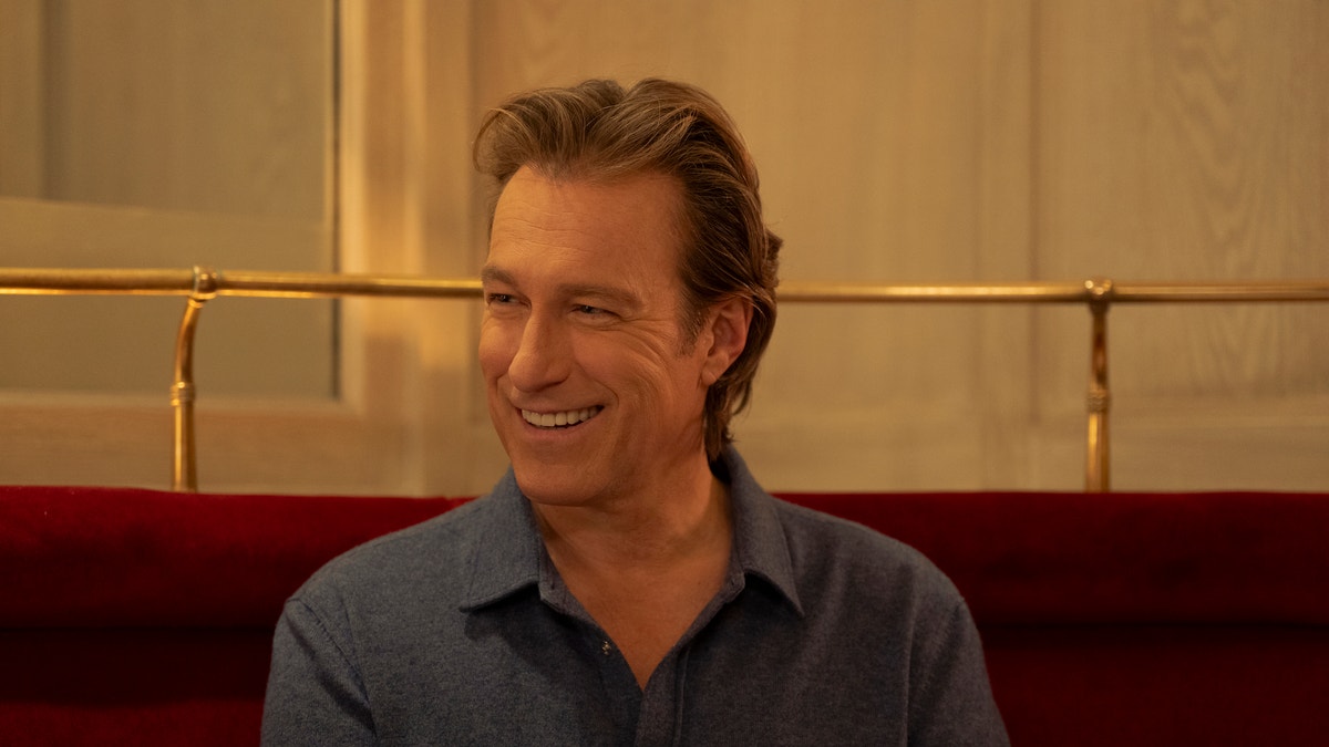 John Corbett smiling in a restaurant booth
