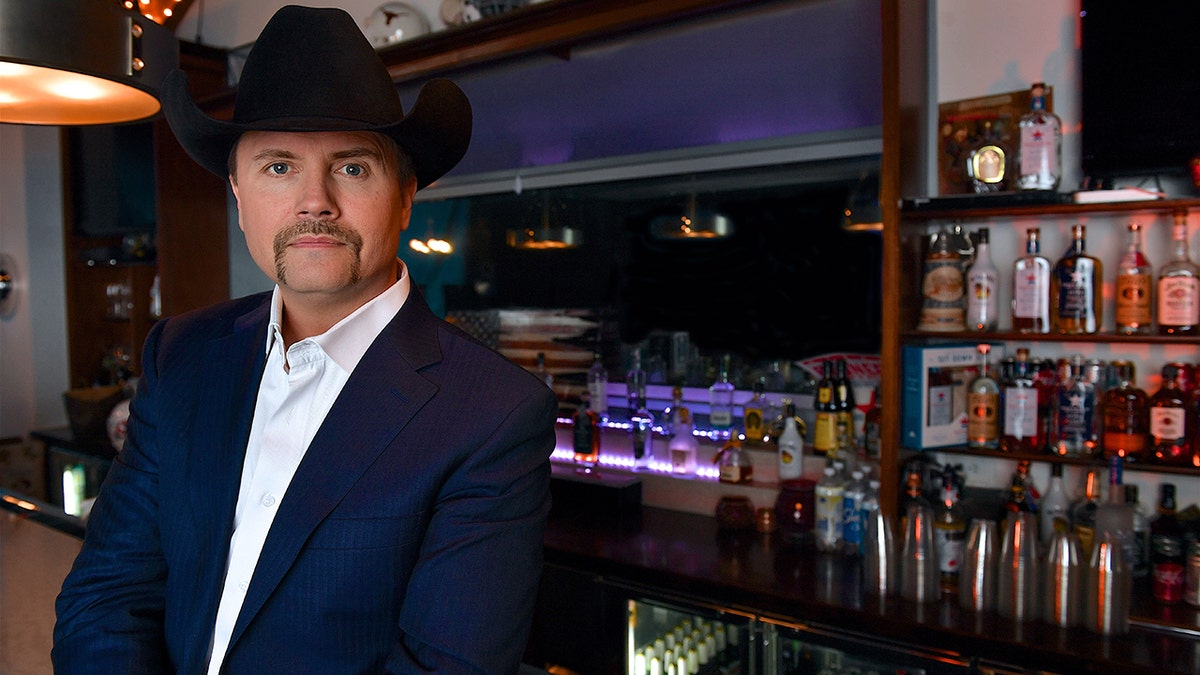 Country singer John Rich wears black cowboy hat at bar