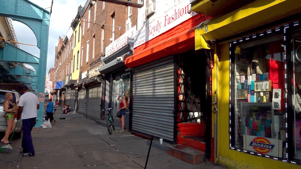 People loiter around shops in Philadelphia's open-air drug market