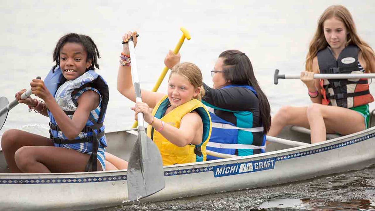 four female campers in a canoe