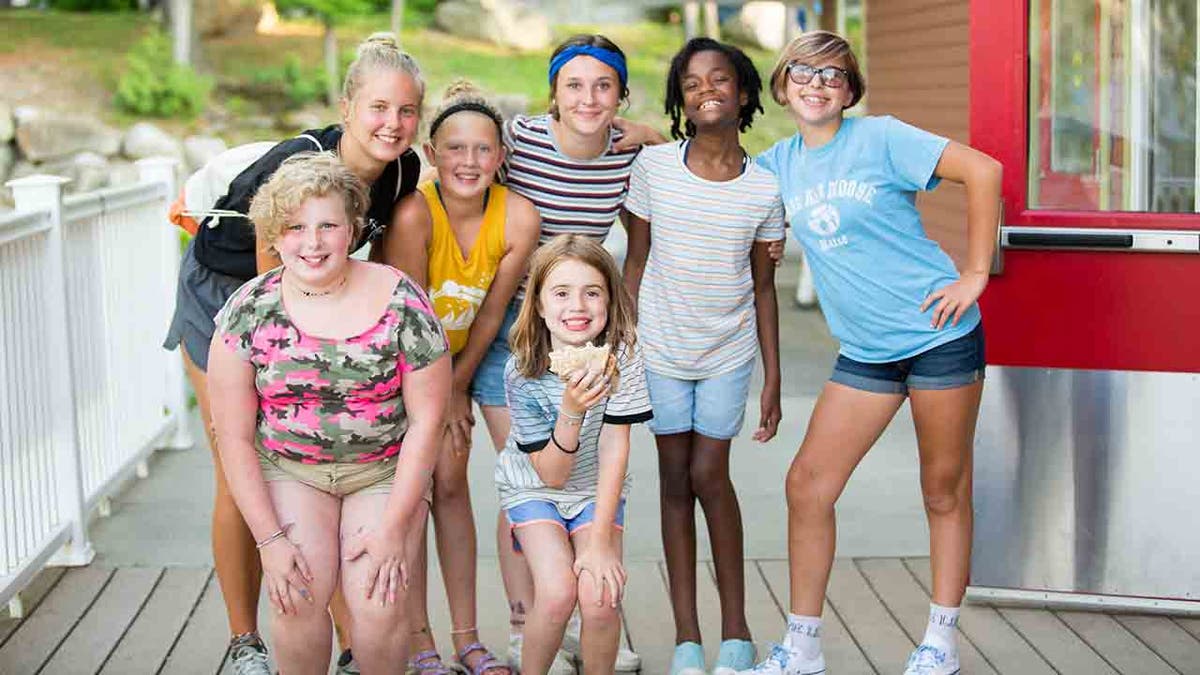 Group shot of female campers outside their cabin