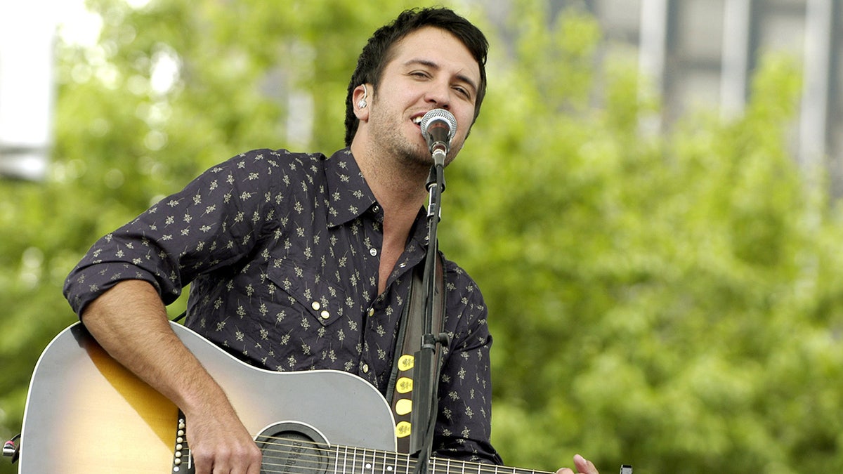 Luke Bryan mengenakan kemeja hitam bermotif di Detroit tampil di atas panggung pada tahun 2007