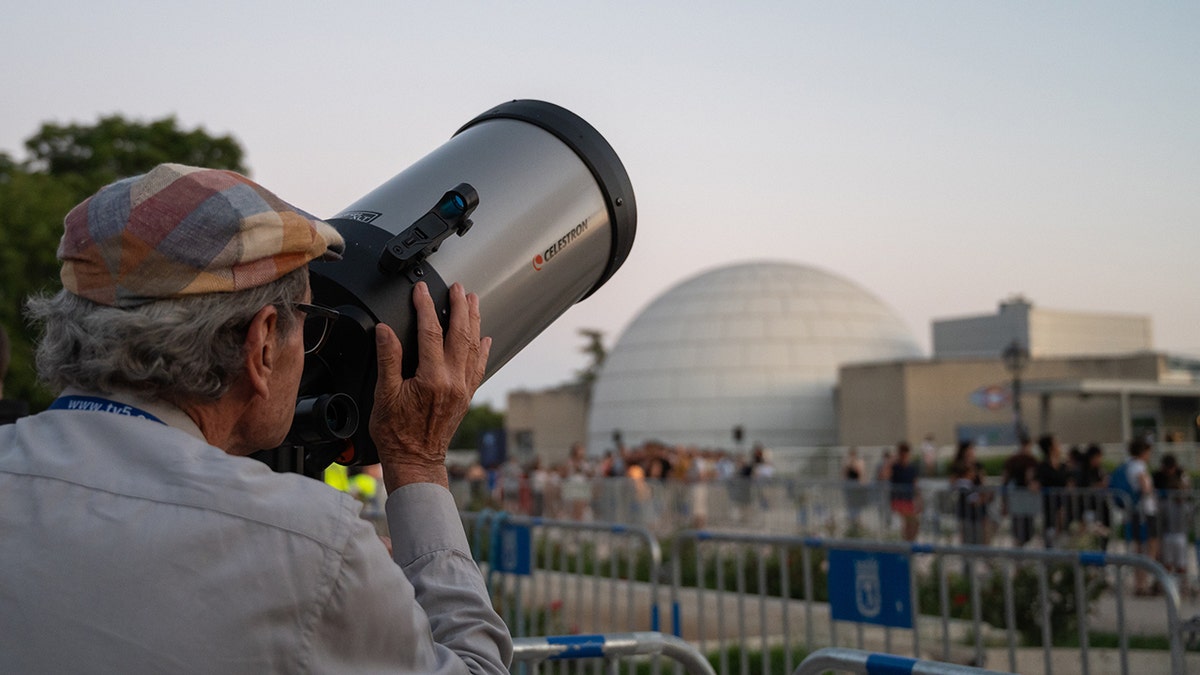 A man looking through a telescope