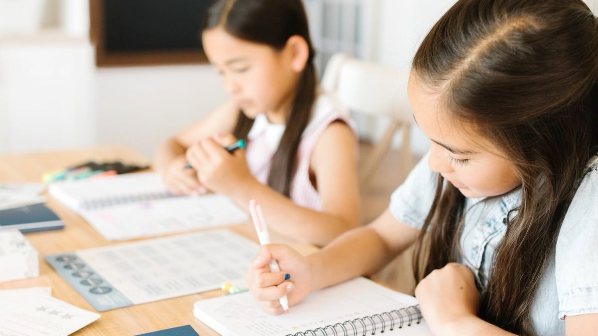 Homeschool kids writing in notebooks