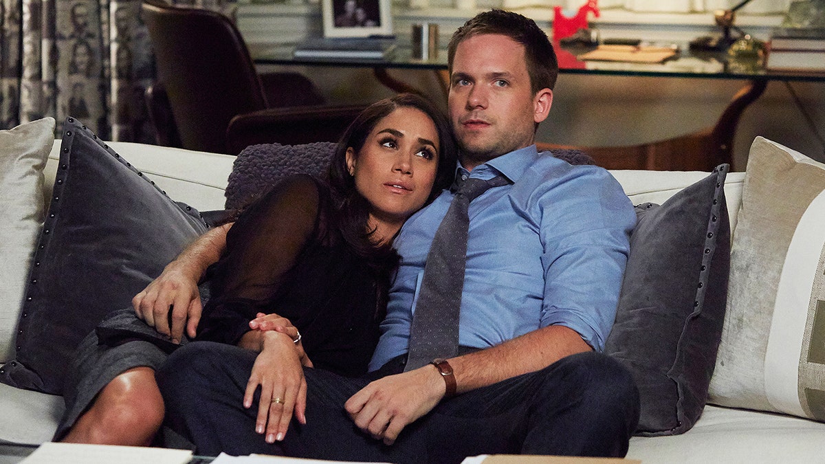 Meghan Markle lies on the couch as Rachel against Patrick J. Adams as Mike in "Suits"
