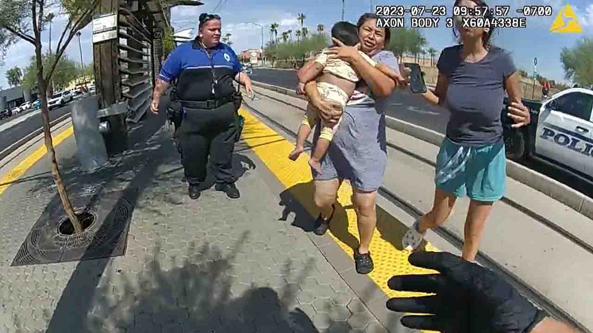 family running baby to officer