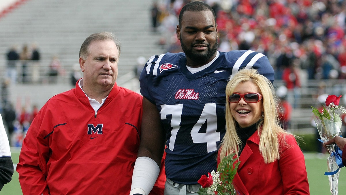 Michael Oher on field with Tuohy family
