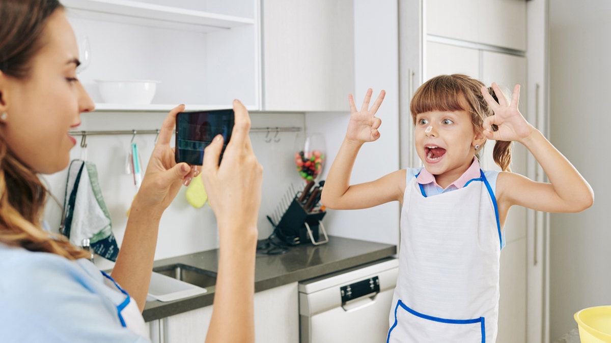 cracking egg trend mom recording daughter for social media