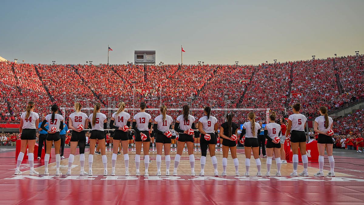 Nebraska volleyball players stand on court