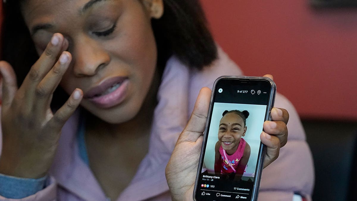 Brittany Tichenor-Cox holds a photo of her daughter
