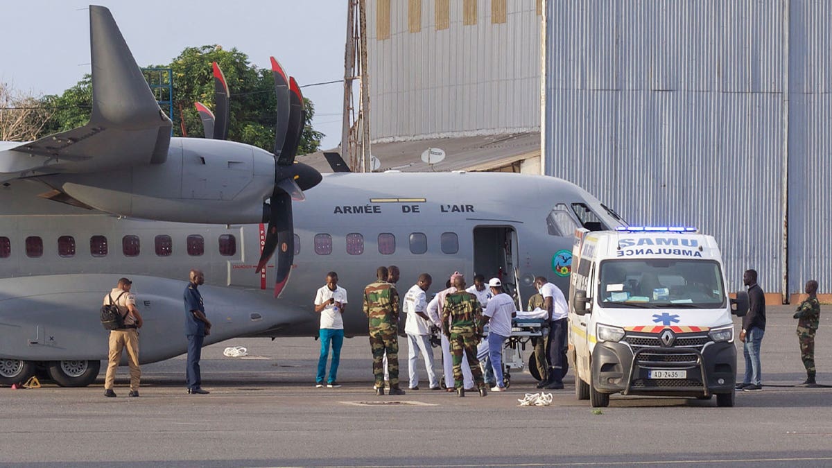 airport personnel transfer migrant survivor into ambulance