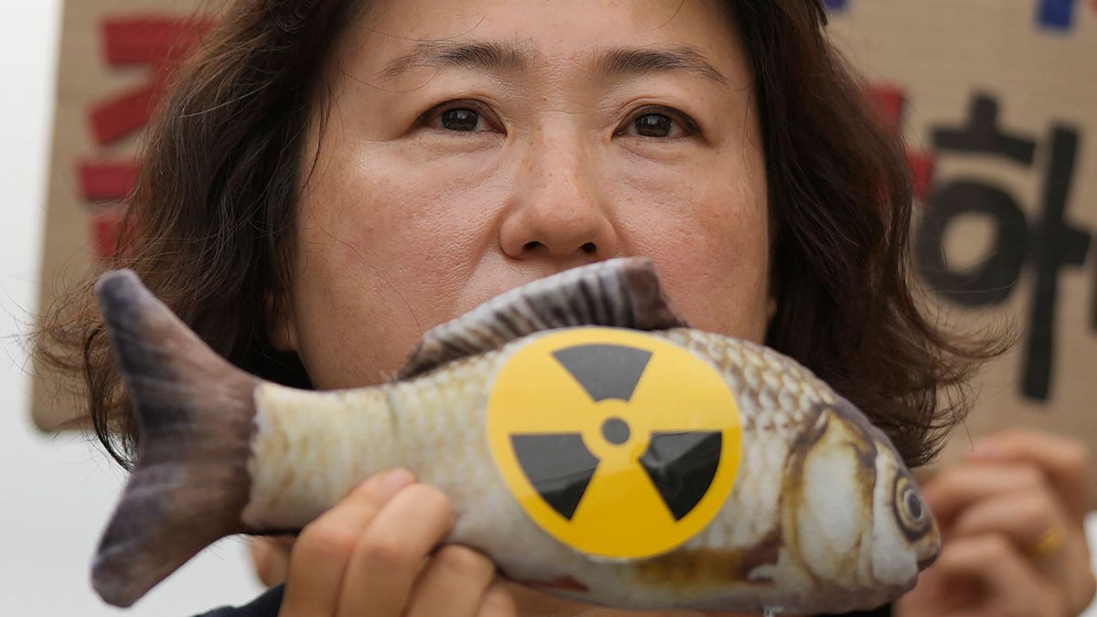 woman holds fish toy