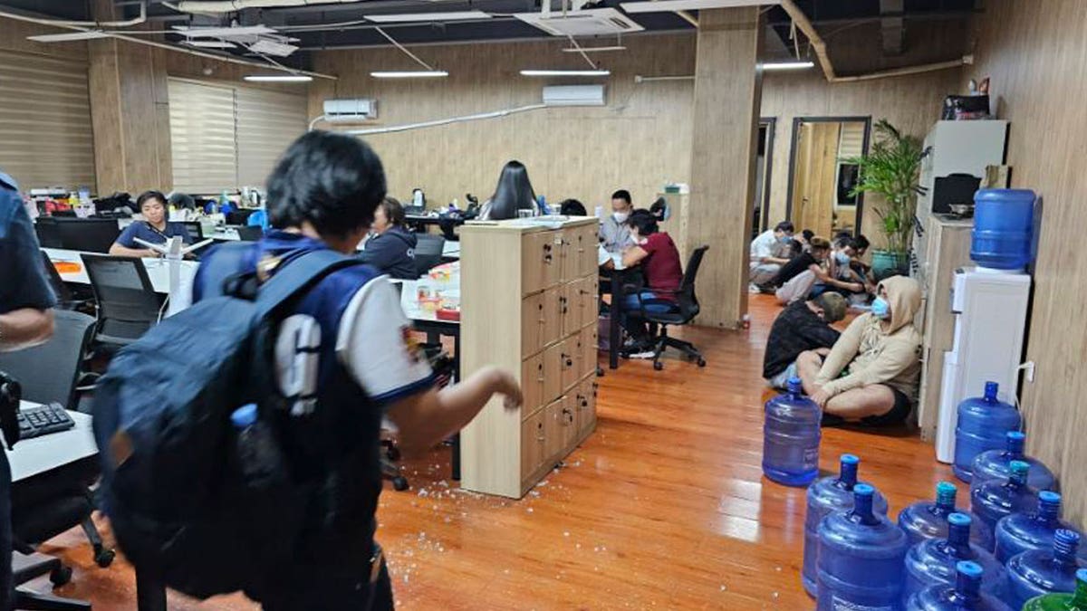 Police walk inside one of the offices they raided in Las Pinas, Philippines, on June 27, 2023. The U.N. human rights office said criminal gangs have forced thousands of people in Southeast Asia into participating in online scams.