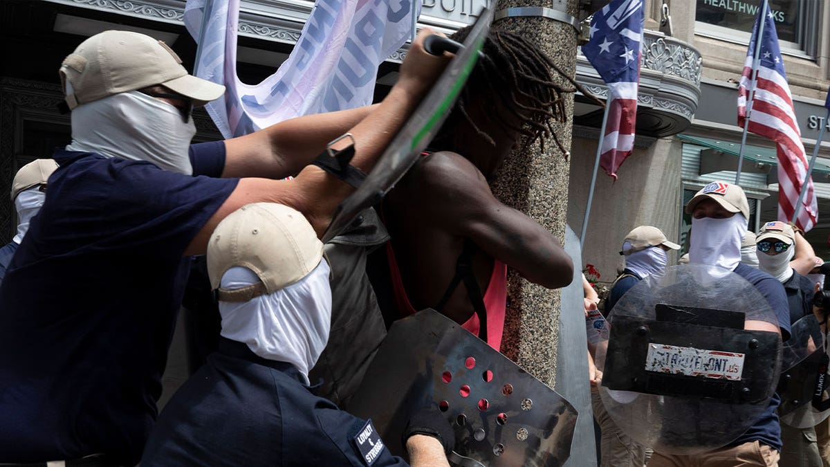 members of Patriot Front shove Black man with shields