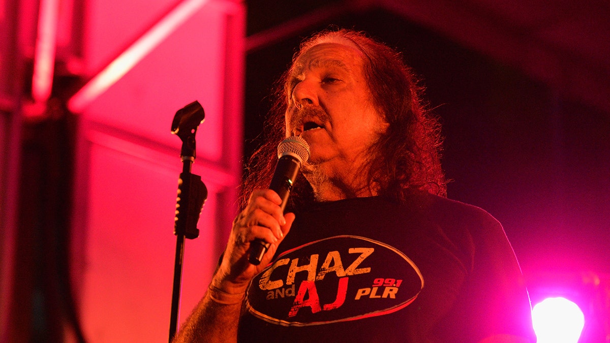 Ron Jeremy holds microphone during bash at Rainbow Bar