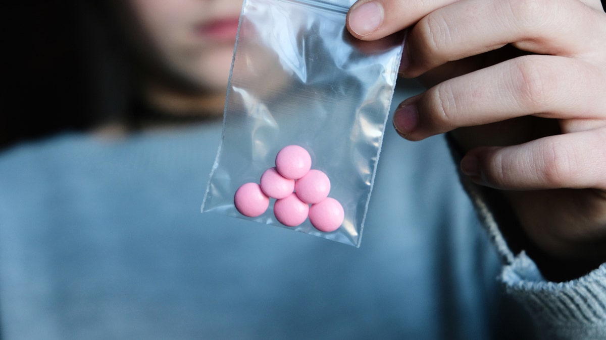 Teen holding pills