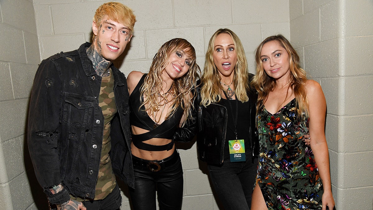 Trace, Miley and Brandi Cyrus pose with their mother Tish at the iHeartRadio Music Festival with Tish making a silly face