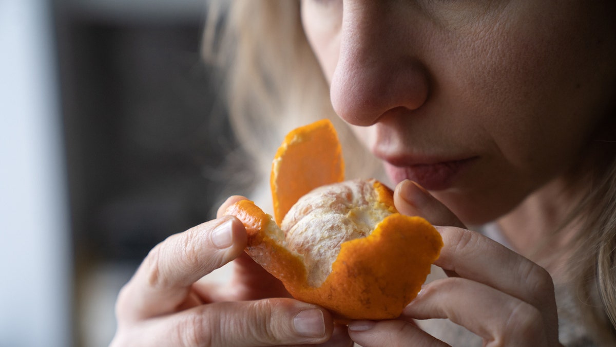 Woman smelling orange
