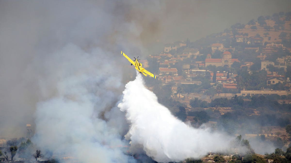 aircraft drops water over fire