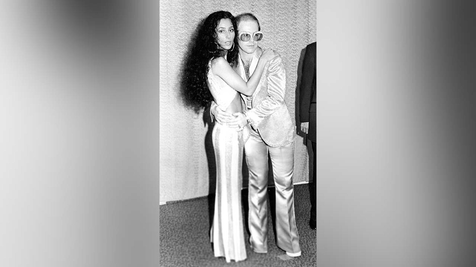 Cher and Elton John pose for a portrait