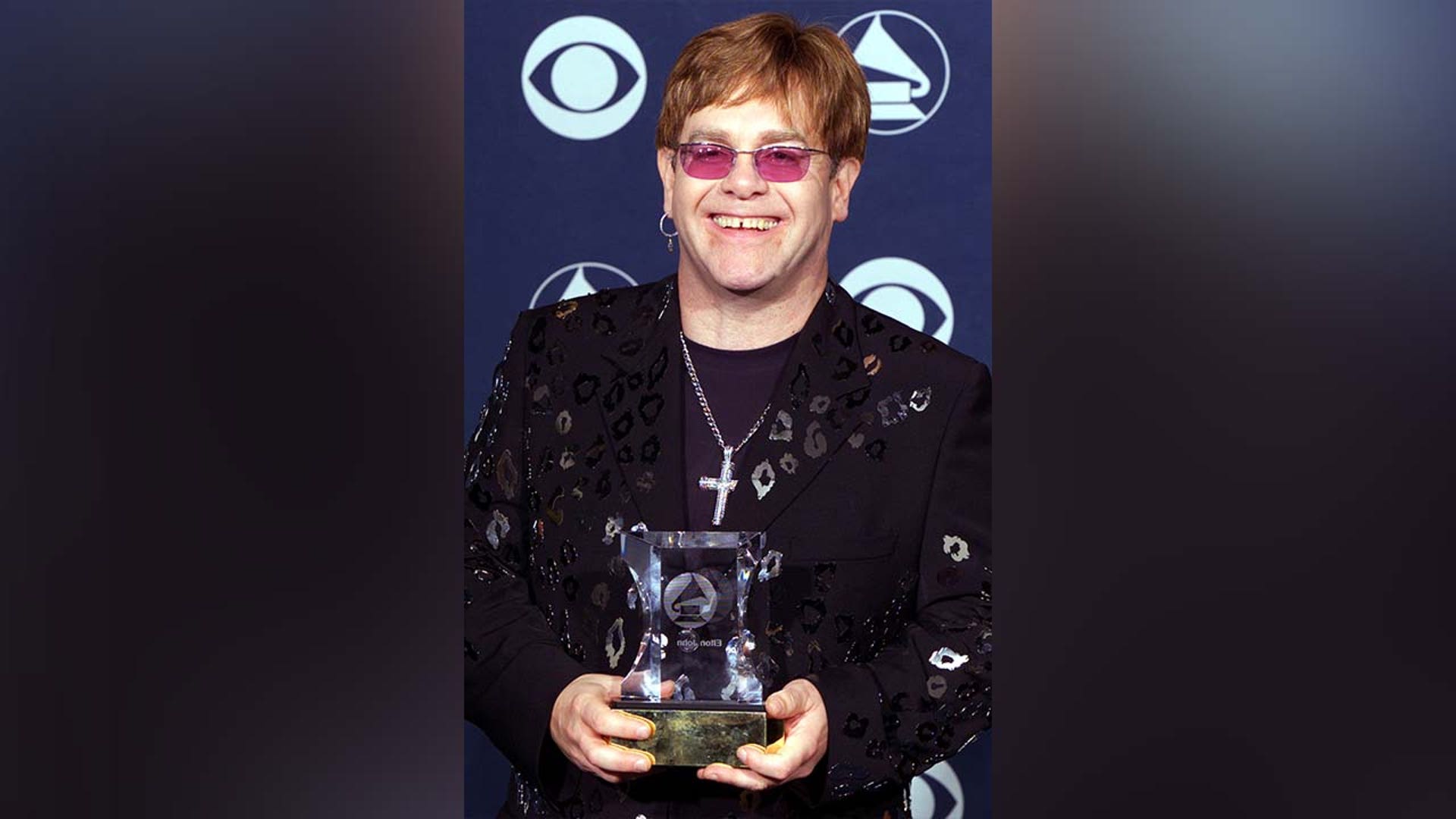 Elton John holds the Grammy Legend Award