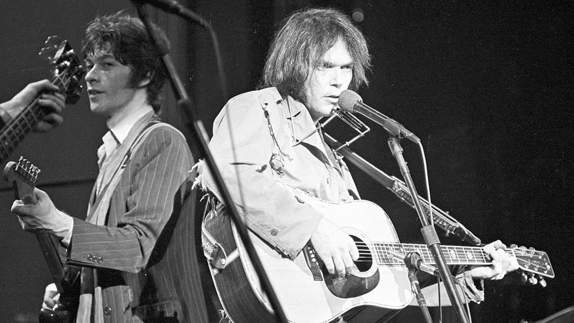 Musician Neil Young performs on stage with Robbie Robertson