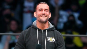 AEW star CM Punk poses with 'trans rights are human rights' sign at All In event