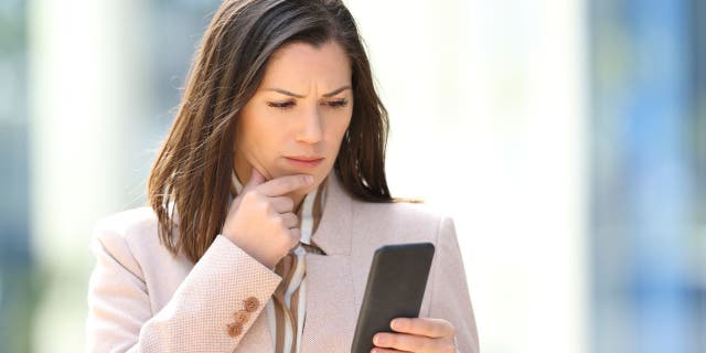 Confused woman looking at her phone