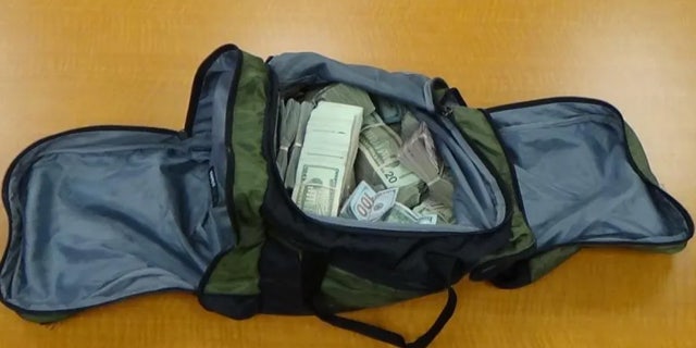 Bolsa de lona llena de dinero en efectivo de la redada de drogas