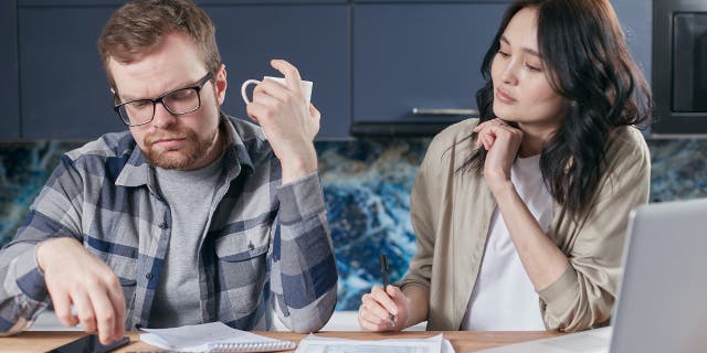 Photo of a husband and wife looking up their insurance company.