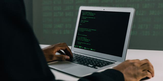 Hacker using his laptop.