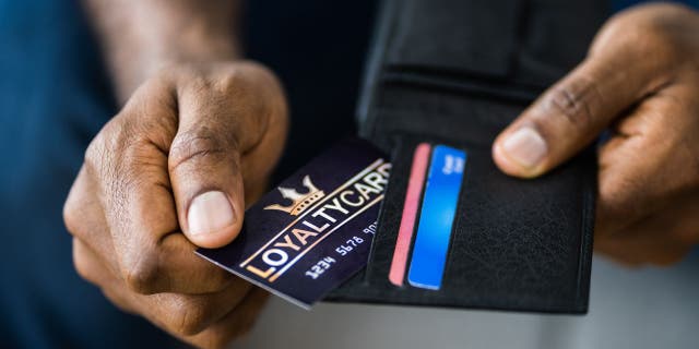 Photo of a man pulling out his loyalty card form his wallet.