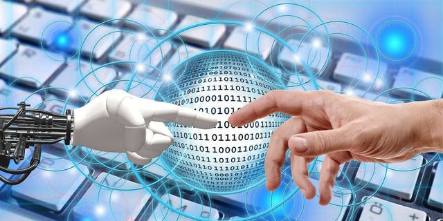 Stock image shows a robot hand reaching toward a human hand