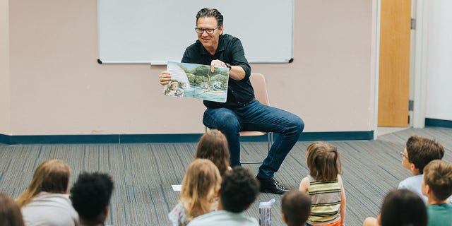 Pastor Brad Jurkovich reading story book to children