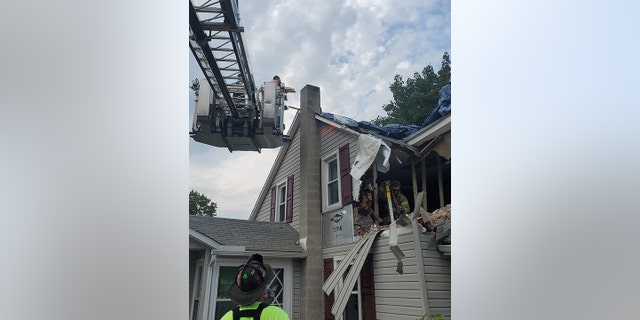 First responders tarp hole in roof