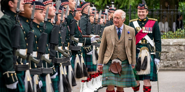 King Charles in a traditional Scottish uniform inspecting his guards
