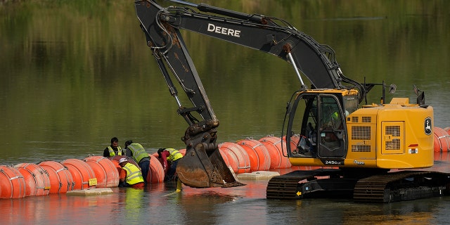 Workers make adjustments to buoys