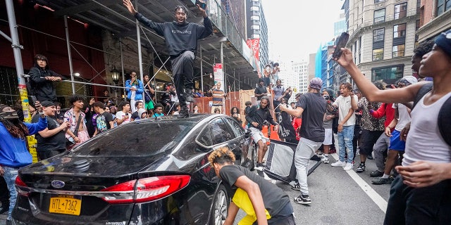 Rioter on top of car during Union Square chaos