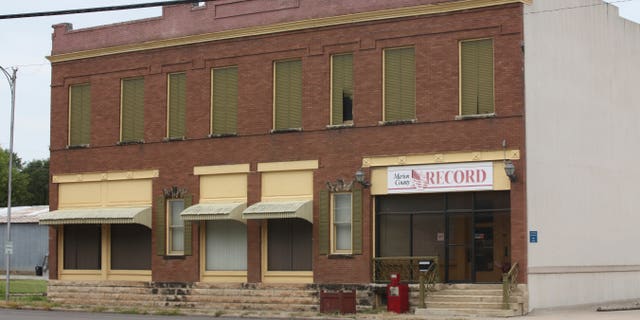 The Marion County Record headquarters, a two-story brick building with blinds and curtains closed