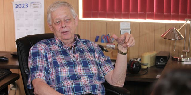 Marion County Record Publisher Eric Meyer in office chair wearing plaid shirt