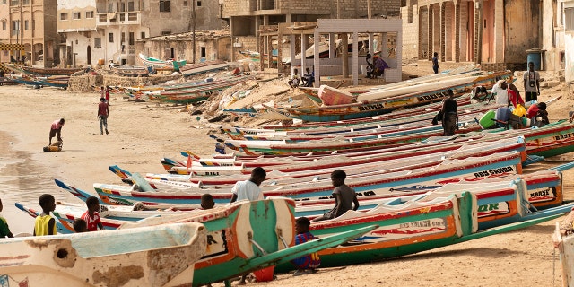 Children play on fishing boats