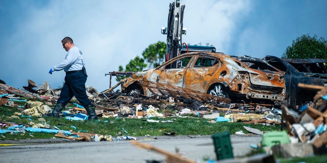 Investigator walking through debris