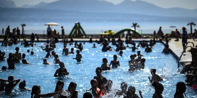 People cool off in the water during hot weather