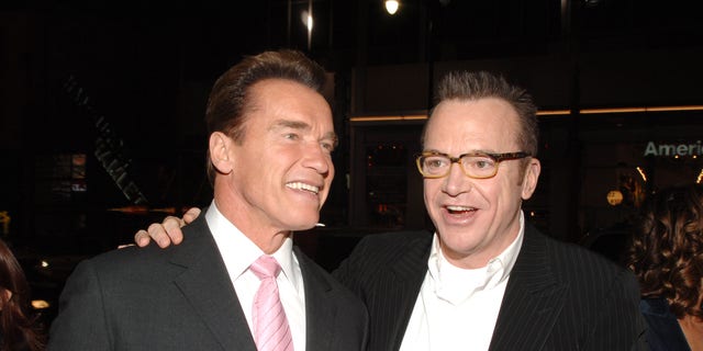 Arnold Schwarzenegger and Tom Arnold posing together