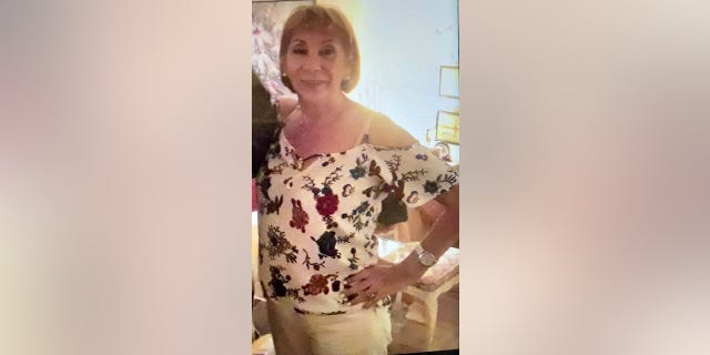 Woman wears floral top in photo.