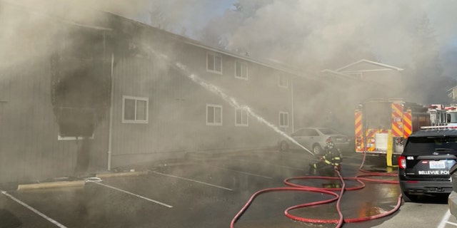 firefighter spraying water onto building