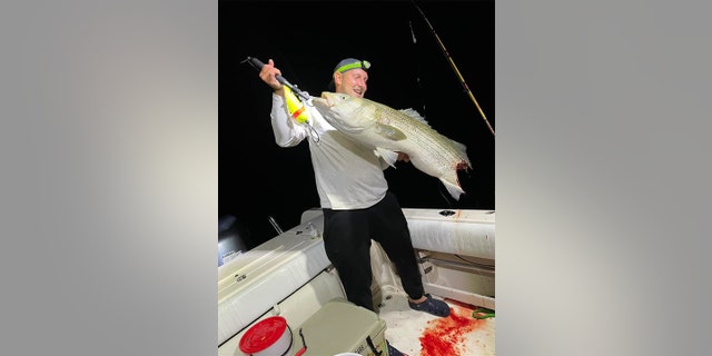 Brian Swiat hold's up half-eaten fish.